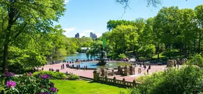 people walking around a fountain in a park next to a river at New2 York Style Stay near Central Park in New York