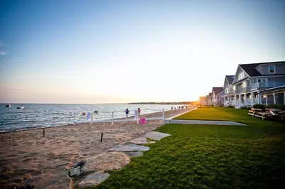 a group of people standing on a beach near the water at Cozy Cottage in Cos Cob in Greenwich