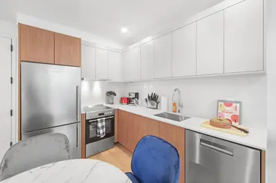 a kitchen with white cabinets and blue chairs in it at 149 Green Street in Brooklyn