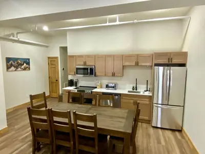 a kitchen with a wooden table and a refrigerator at Luxury Townhome 107 in Wilmington