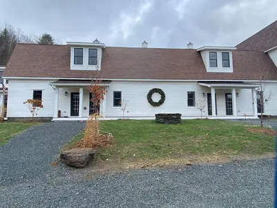 a white house with areath on the front of it at Luxury Townhome 105 in Wilmington