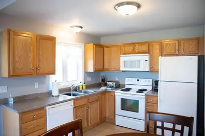 a kitchen with white appliances and wooden cabinets at 11 - 4 Bedrooms 3 Baths Sleeps up to 10 in Plainville