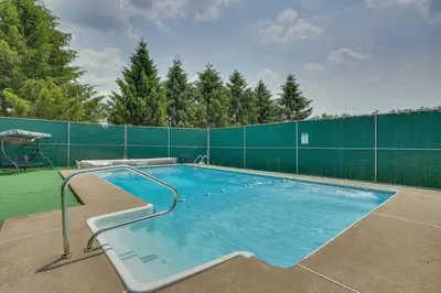 a large swimming pool with a green fence at 2BR Premium Duplex Close to Ski Slopes in Pleasant Mount