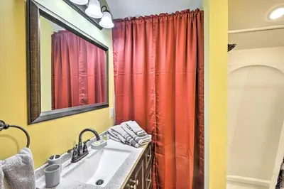 a bathroom with a sink and a red shower curtain at Suite to Unwind Close to Ski Slopes in Pleasant Mount
