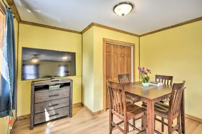 a dining room with a table and a tv at Home Away from the City Close to Ski Trails in Pleasant Mount
