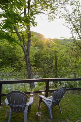 two chairs and a table on a porch with a view at Perch Cottages #15 - Creek Access, Sauna, Mt views in Boiceville