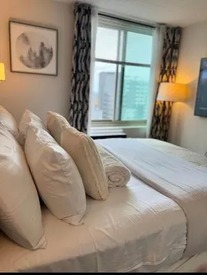 a bedroom with a bed with pillows and a window at NEW Modern 2BR w Fireplace & Fitness Lounge, Live Comfortably in East Harlem in New York