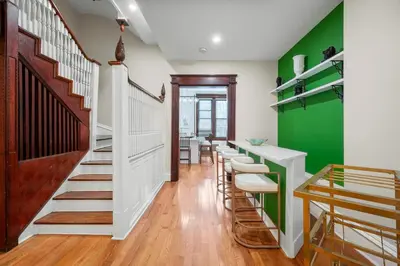 a hallway with green walls and a row of stools at Luxury Townhouse in NYC in New York