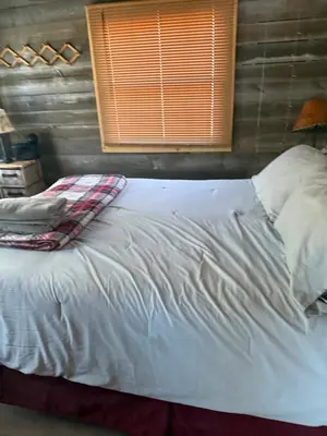 a large white bed in a room with a window at Tiny house of Walnut Grove in Ashland