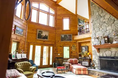 a living room with a fireplace and a stone wall at Country Getaway Nestled in Enchanting Westchester County near New York City in Bedford