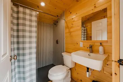 a bathroom with a toilet and a sink at Large Safari Tent on the Hudson River, Perfect for a Family Glamping Getaway in Corinth
