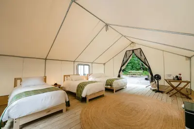 a room with two beds in a tent at Luxury Canvas Group Glamping Tent | Adirondacks in Corinth, NY in Corinth