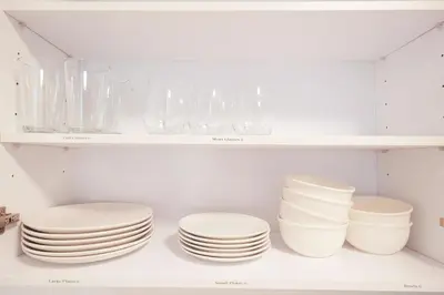 a bunch of plates and bowls on a shelf at The Platinum Downtown Stamford Studio Getaway in Stamford