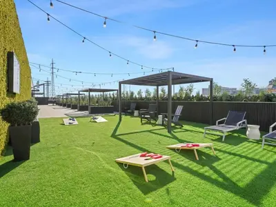 a patio with chairs and a table on the grass at The Platinum Downtown Stamford Studio Getaway in Stamford