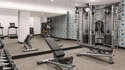 a gym with several tread machines and mirrors at The Vibe on 5th IV Vibe 8753 in New York