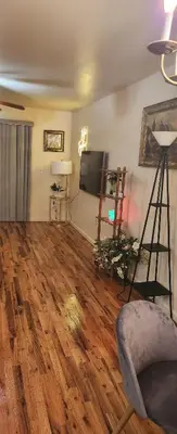 a living room with wooden floors and a flat screen tv at Beautiful Room king in Newark