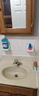 a bathroom counter with a sink and a mirror at Amazing family house in Newark