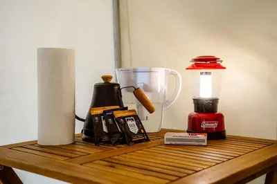 a counter with a blender on a table with a lamp at Classic Safari Tent in the Heart of the Adirondack Wilderness, near Lake George, New York in Corinth