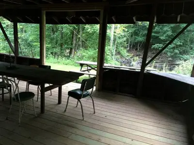 a screened in porch with a table and chairs at Romantic Mountain Cabin with Stunning Views in Ulster County, New York in Shandaken