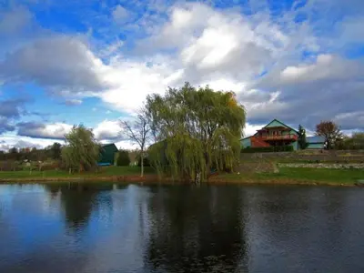 a large lake with a house in the background at Gorgeous Getaway Suite in a Converted Barn near Hudson, New York in Hudson