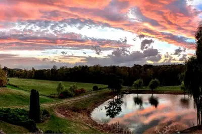 a sunset over a pond in a field at Pet-Friendly Vacation Rental on a Working Farm near Hudson, New York in Hudson