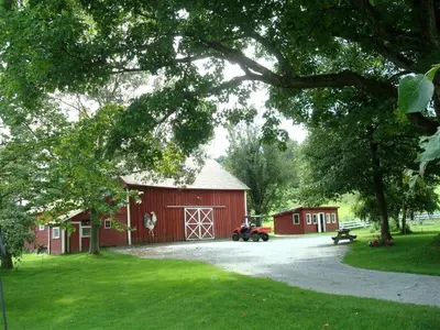 a red barn with a car parked in front of it at Enchanting Secluded Cabin Rental near Salem, New York in Salem
