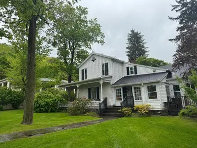 a white house with a yard at Book Village Inn - Hemingway Room King Bed in Hobart