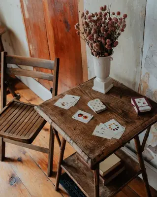 a wooden table with a vase of flowers and a chair at Book Village Inn - Entire Hotel in Hobart