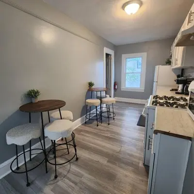 a kitchen with four bar stools and a counter at Private Bedroom w Shared Space A in South Hackensack