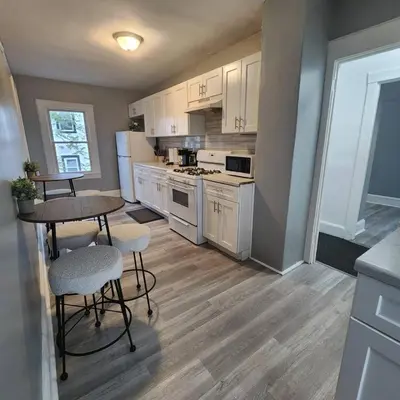 a kitchen with white appliances and a table and chairs at Private Bedroom In Shared Apt C in South Hackensack