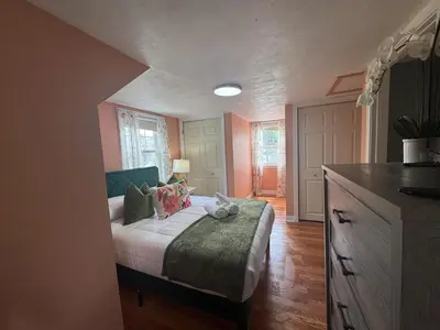 a bedroom with a bed with a green blanket at Cozy Home in New Britain
