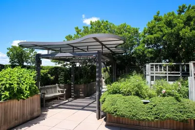 a bench under an umbrella in a garden at Gorgeous Studio Apartment in New York