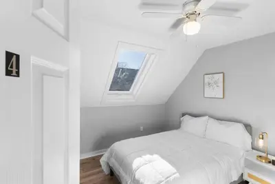 a white bedroom with a bed and a window at SCSU Two Bedroom Suite in New Haven