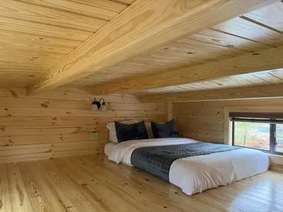 a bedroom with a bed in a wooden cabin at Tiny Cabin #3 by Windham NY Escape 'Forest View' in Hensonville