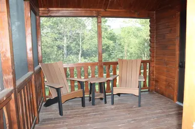 two chairs and a table on the porch of a cabin at Tiny Cabin #3 by Windham NY Escape 'Forest View' in Hensonville