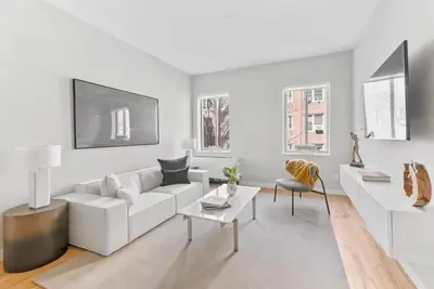 a white living room with a white couch and a table at Top Notch 2BR & 2BA Suite Minutes to Central Park in New York