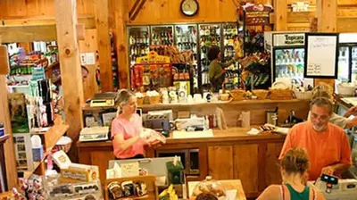 a group of people standing at a counter in a store at Luxury Jiminy Ski On Off Village Ctr Condo Sleeps4 in Hancock