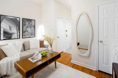 a living room with a couch and a mirror at Serene 1B Upper East Side Retreat in New York