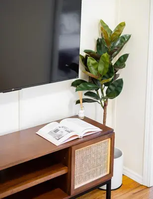 a table with a book and a potted plant on it at Serene 1B Upper East Side Retreat in New York