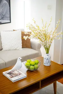 a coffee table with a bowl of fruit and a vase at Serene 1B Upper East Side Retreat in New York