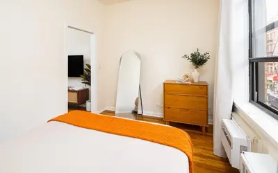 a bedroom with a bed and a dresser and a mirror at Serene 1B Upper East Side Retreat in New York