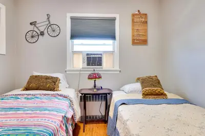 a bedroom with two beds and a bike on the wall at 5 Mi to Dtwn Newark Hillside Vacation Rental in Hillside