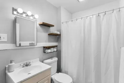 a bathroom with a white shower curtain and a toilet at Cozy Bedroom next to SCSU in New Haven