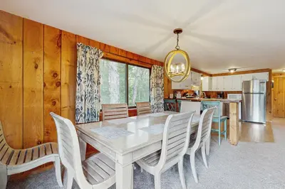 a dining room with a white table and chairs at Ski Haus Retreat - Unit B in Dover