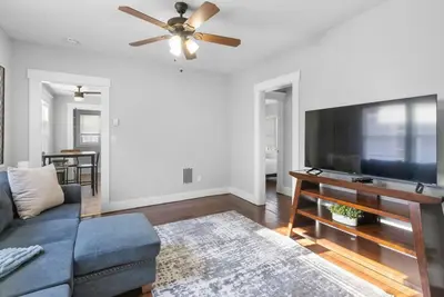 a living room with a couch and a flat screen tv at Sunny Room Steps from SCSU in New Haven