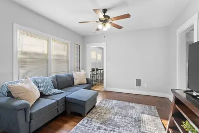 a living room with a couch and a ceiling fan at Sunny Room Steps from SCSU in New Haven