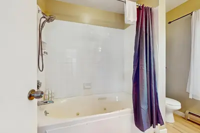 a white bathroom with a tub and a toilet at 17A Mountain Village #241 in Dover