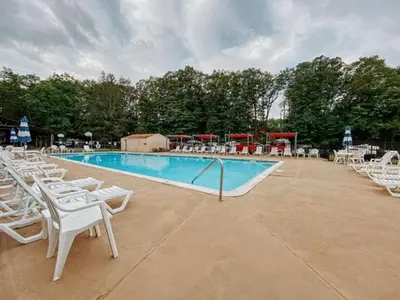 a swimming pool with white chairs and a bunch ofitures at Peaceful Dome Getaway in the Catskills in Gilboa