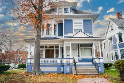 a blue house with a tree in front of it at The Nest At Elm City Flats in New Haven