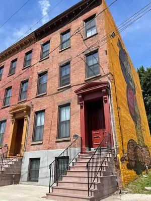 a large brick building with a red door and stairs at Beautiful 2 BED 2 BATH Soaker Tub in Albany